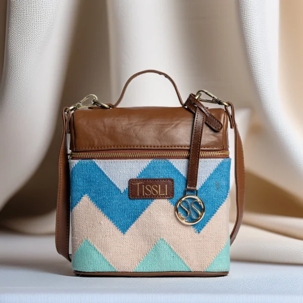 Tissli Coastal Calm handwoven backpack with blue and green zigzag rug pattern and brown vegan leather straps.