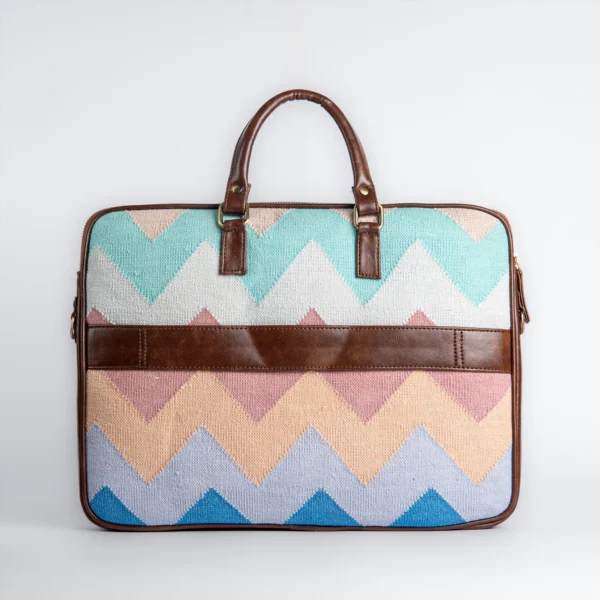 Back view of Tissli handwoven azure chevron rug laptop bag featuring a premium brown vegan leather luggage strap.