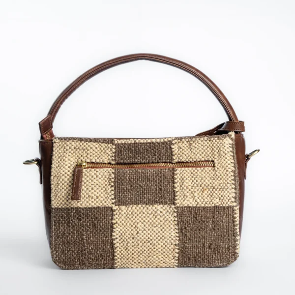 Side view of Tissli checkers grid handwoven sling bag showing 9cm depth and premium brown vegan leather piping.