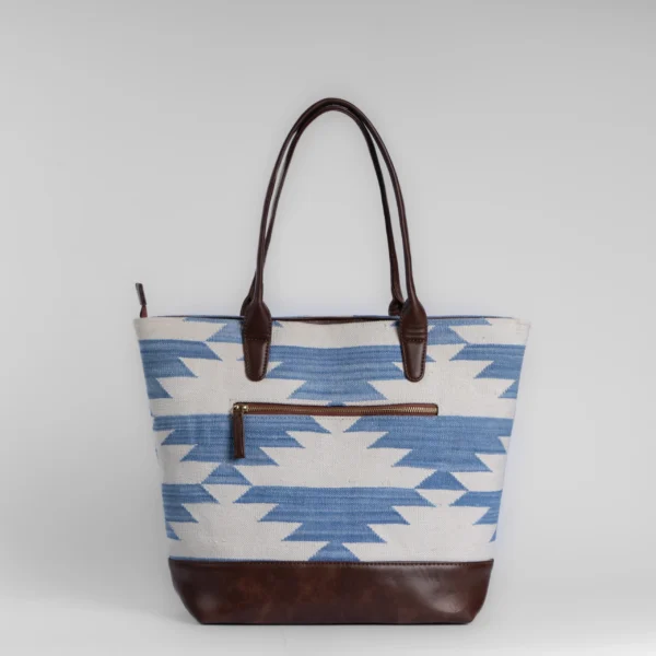 Blue and white Cotton Panja woven rug tote bag with vegan leather base, inspired by Indian stepwell architecture.