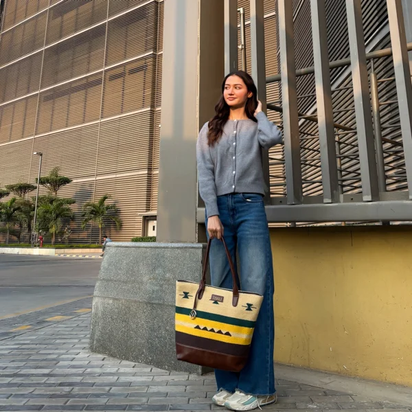 Tissli mustard yellow and forest green handwoven rug tote with chocolate brown leather base and tribal motifs.