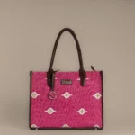 Tissli magenta handwoven rug tote with white and gold tribal diamond motifs and chocolate leather trim.